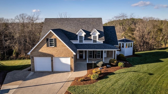 view of front facade with brick siding, covered porch, a shingled roof, concrete driveway, and a front yard