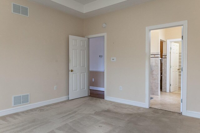 unfurnished bedroom featuring baseboards, visible vents, and light colored carpet