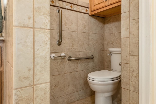 bathroom featuring tile patterned floors, tile walls, and toilet