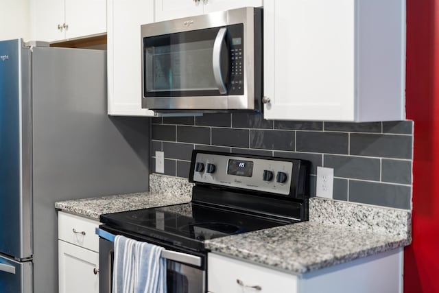 10 Zephyr Rd, Palmyra, VA 22963 - kitchen with appliances with stainless steel finishes, white cabinetry, backsplash, and light stone counters