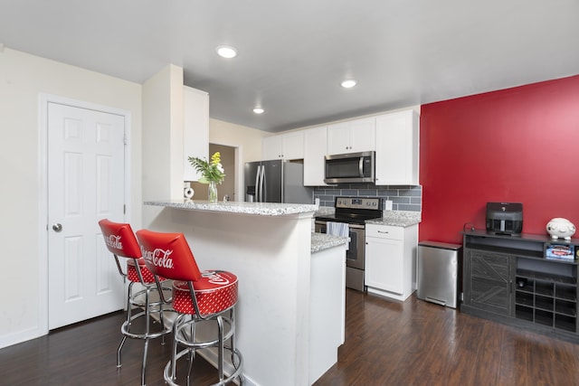 10 Zephyr Rd, Palmyra, VA 22963 - kitchen with appliances with stainless steel finishes, dark wood-style floors, a breakfast bar, white cabinetry, and recessed lighting