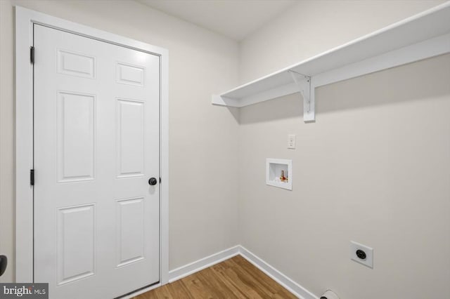 clothes washing area featuring hookup for an electric dryer, baseboards, wood finished floors, and hookup for a washing machine