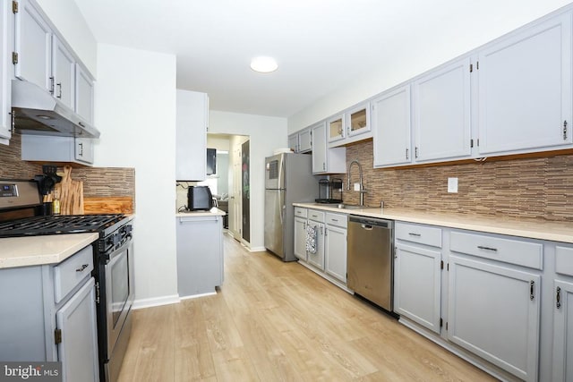769 Cherry Tree Ln, Warrenton, VA 20186 - kitchen with appliances with stainless steel finishes, under cabinet range hood, backsplash, and light wood-type flooring