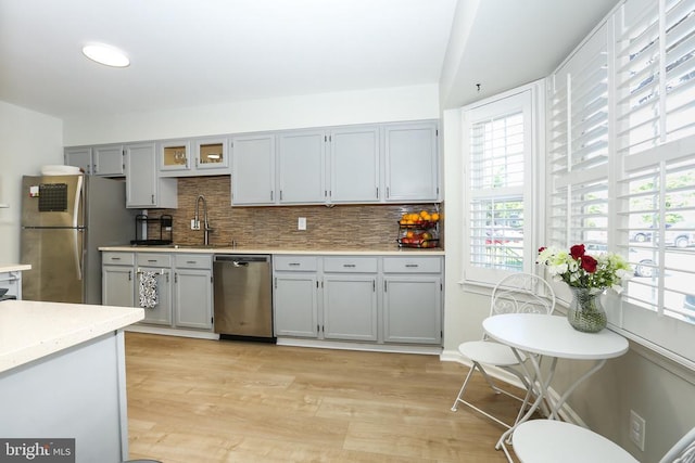 769 Cherry Tree Ln, Warrenton, VA 20186 - kitchen with appliances with stainless steel finishes, gray cabinetry, tasteful backsplash, and light wood-type flooring