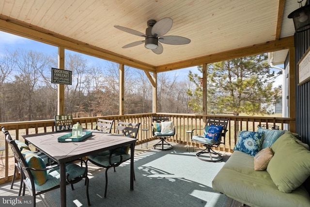 sunroom / solarium with wood ceiling and a ceiling fan