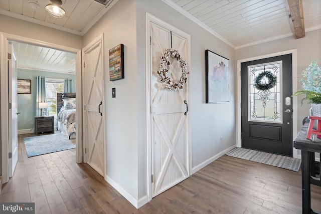 entrance foyer with ornamental molding, wooden ceiling, hardwood / wood-style flooring, and baseboards