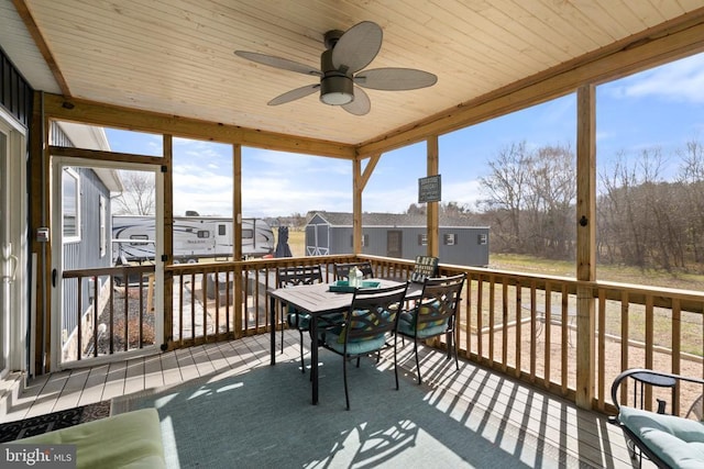 sunroom / solarium featuring a ceiling fan and wood ceiling