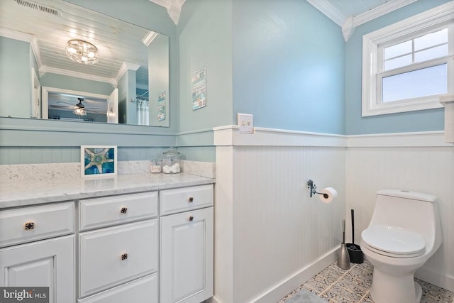 bathroom with a wainscoted wall, crown molding, visible vents, toilet, and vanity