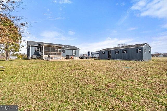 view of yard featuring an outbuilding, a sunroom, and cooling unit