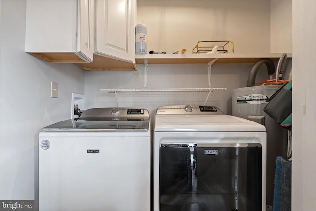 laundry area featuring cabinet space, washer and clothes dryer, and water heater