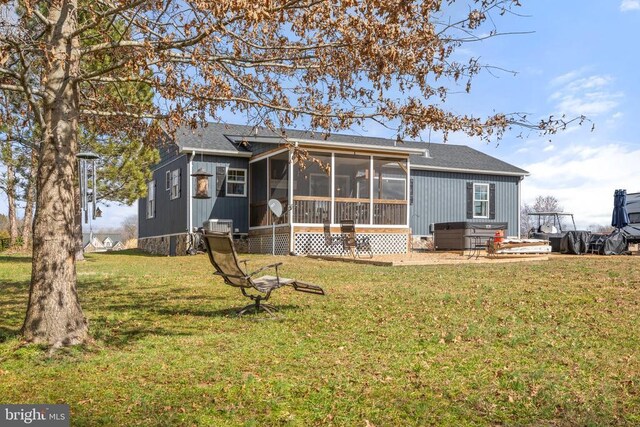 rear view of house featuring a sunroom and a yard