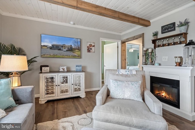 living area featuring wood finished floors, wood ceiling, beamed ceiling, a glass covered fireplace, and crown molding