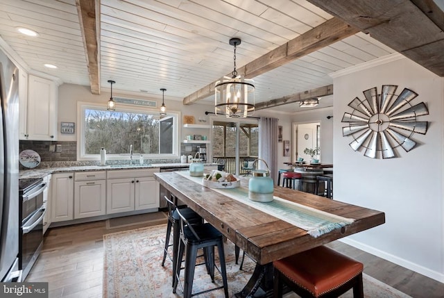 kitchen with stainless steel appliances, light wood-type flooring, backsplash, and beam ceiling