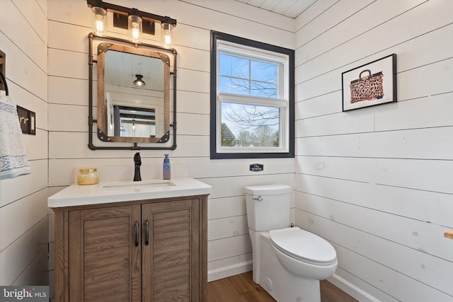 bathroom with toilet, wood finished floors, and vanity