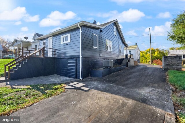 view of property exterior featuring stairway and central air condition unit