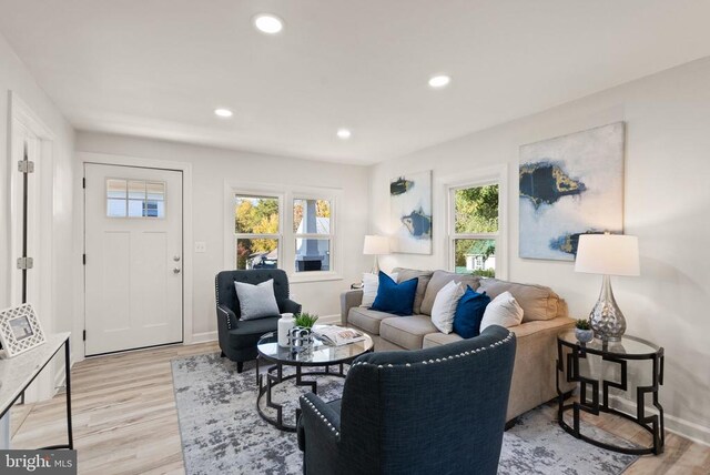 living area with baseboards, light wood-style flooring, and recessed lighting