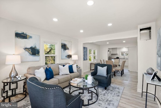 living room with light wood-style floors, recessed lighting, and baseboards