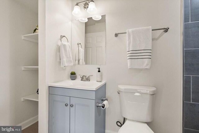 bathroom with vanity, toilet, and baseboards