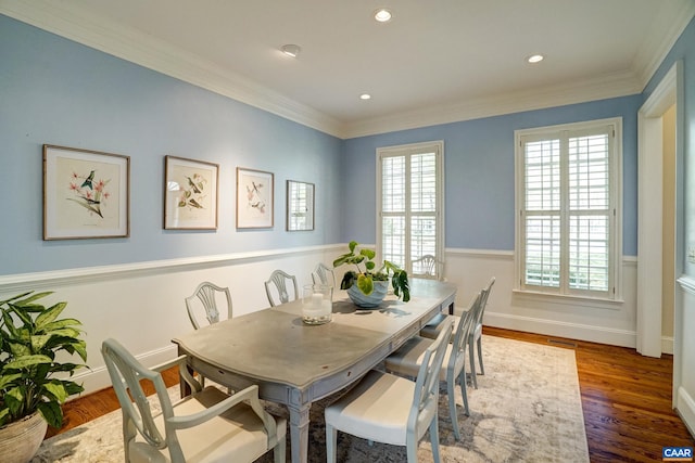 dining space with crown molding, a wealth of natural light, and wood finished floors