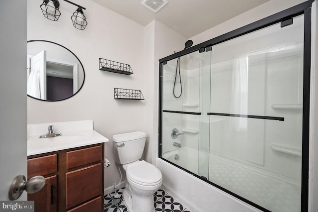full bath featuring vanity, toilet, combined bath / shower with glass door, and baseboards