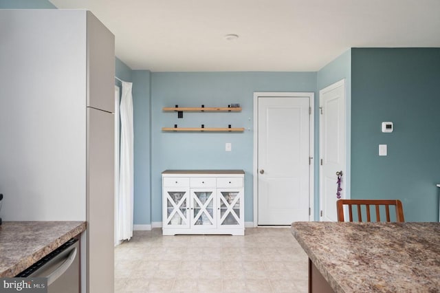kitchen featuring freestanding refrigerator and baseboards