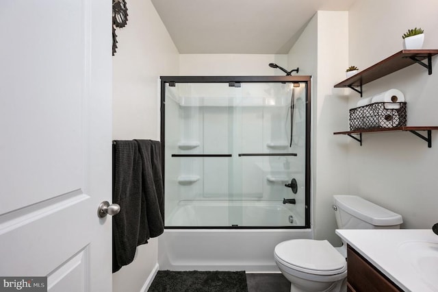 bathroom with vanity, bath / shower combo with glass door, and toilet