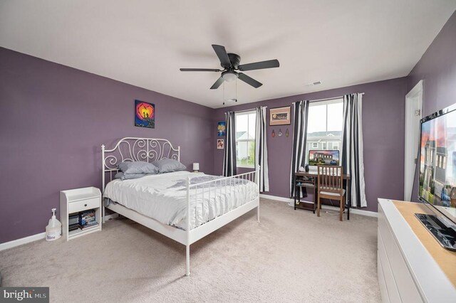 bedroom with light colored carpet, baseboards, and ceiling fan