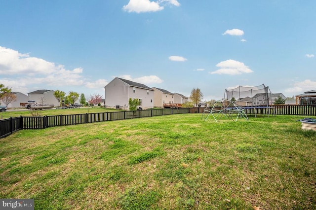 view of yard with a trampoline and a residential view