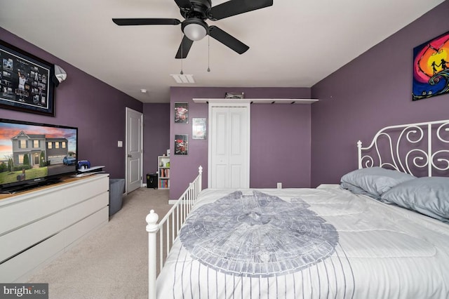bedroom with light carpet, a closet, and a ceiling fan