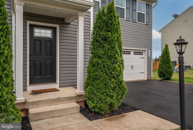 property entrance with an attached garage and driveway