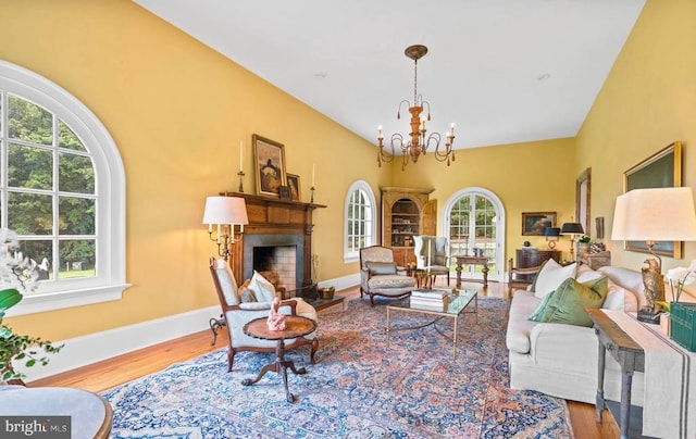 8833 Wales Rd N, Warrenton, VA 20186 - living area featuring healthy amount of natural light, wood finished floors, a chandelier, and a fireplace with raised hearth