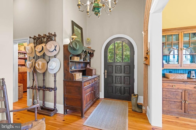 8833 Wales Rd N, Warrenton, VA 20186 - entrance foyer featuring light wood finished floors, a chandelier, a towering ceiling, and arched walkways