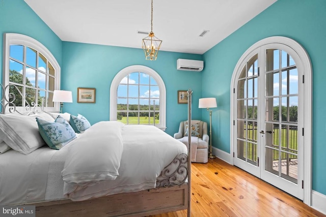 8833 Wales Rd N, Warrenton, VA 20186 - bedroom featuring an AC wall unit, wood-type flooring, and access to outside