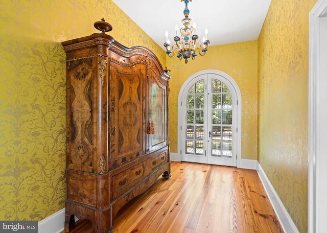 8833 Wales Rd N, Warrenton, VA 20186 - foyer with light wood-style flooring, a chandelier, wallpapered walls, and vaulted ceiling