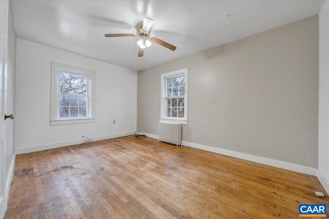 2420 James River Rd, Esmont, VA 22937 - unfurnished room featuring a ceiling fan, radiator, hardwood / wood-style floors, and a healthy amount of sunlight