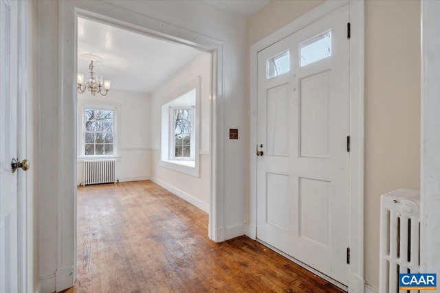 2420 James River Rd, Esmont, VA 22937 - foyer entrance featuring an inviting chandelier, radiator, a healthy amount of sunlight, and wood finished floors