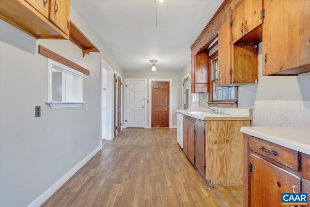 2420 James River Rd, Esmont, VA 22937 - kitchen featuring a sink, light wood finished floors, brown cabinetry, and light countertops