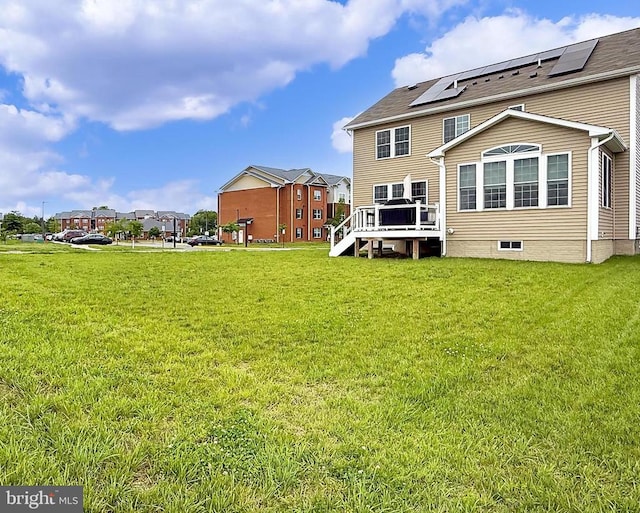 2020 Captain Dr, Fredericksburg, VA 22408 - back of property with a deck, a lawn, and roof mounted solar panels