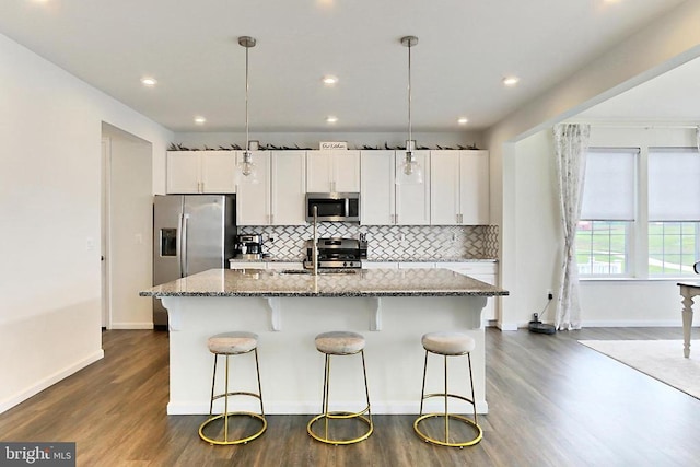 2020 Captain Dr, Fredericksburg, VA 22408 - kitchen with stainless steel appliances, a sink, a center island with sink, dark wood-style floors, and a breakfast bar area