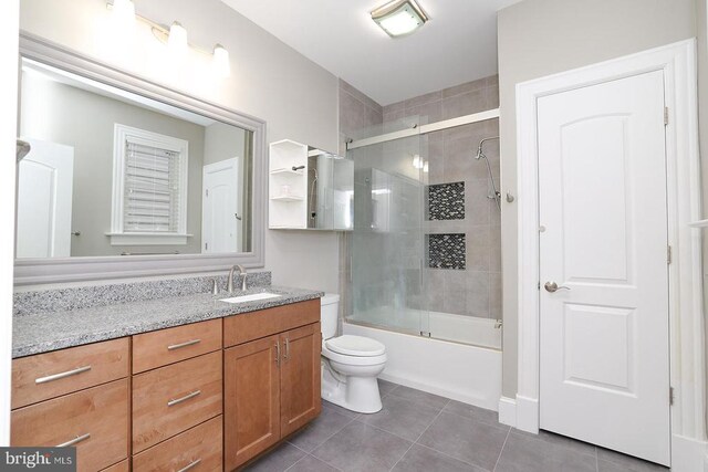  - full bath featuring tile patterned flooring, vanity, toilet, and combined bath / shower with glass door