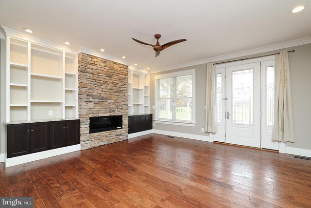  - unfurnished living room with crown molding, a ceiling fan, wood finished floors, a fireplace, and baseboards