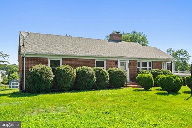 130 Morningside Dr, Culpeper, VA 22701 - view of front facade featuring brick siding, a front yard, a chimney, a storage unit, and roof with shingles