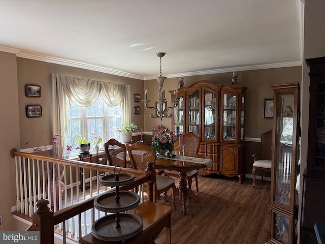 dining space featuring wood finished floors, a chandelier, and ornamental molding