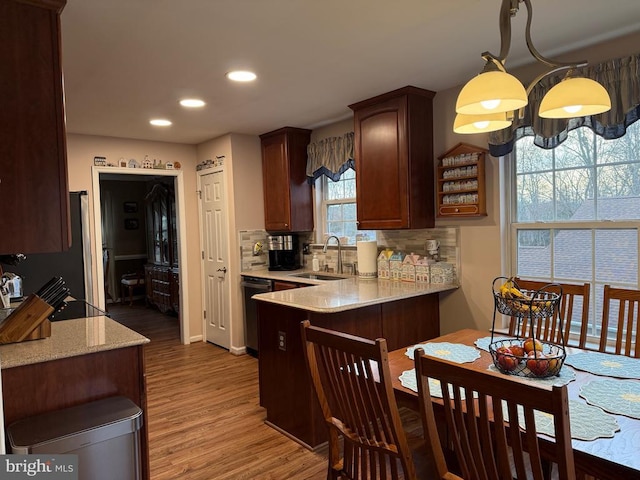 kitchen with a sink, dishwasher, light wood-type flooring, recessed lighting, and a peninsula