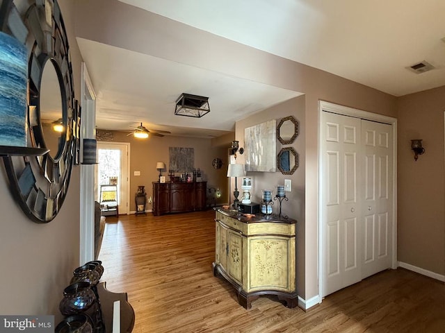 corridor featuring light wood-style floors and baseboards
