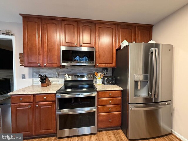 514 Constitution Blvd, Locust Grove, VA 22508 - kitchen with appliances with stainless steel finishes, tasteful backsplash, light wood finished floors, and light stone counters