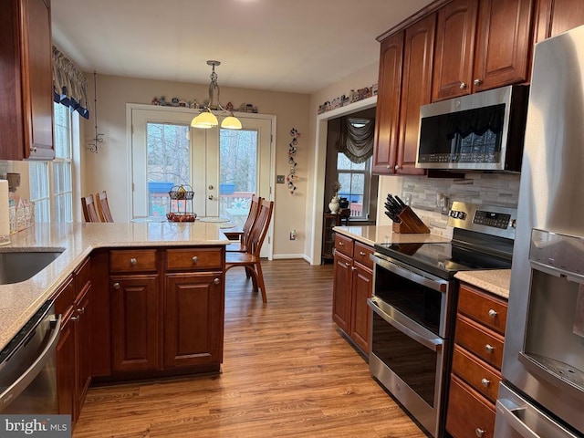 kitchen with stainless steel appliances, light wood finished floors, french doors, and plenty of natural light