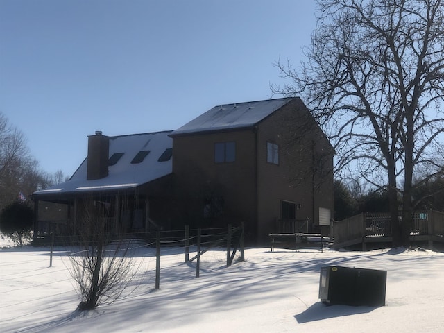 snow covered back of property featuring a trampoline