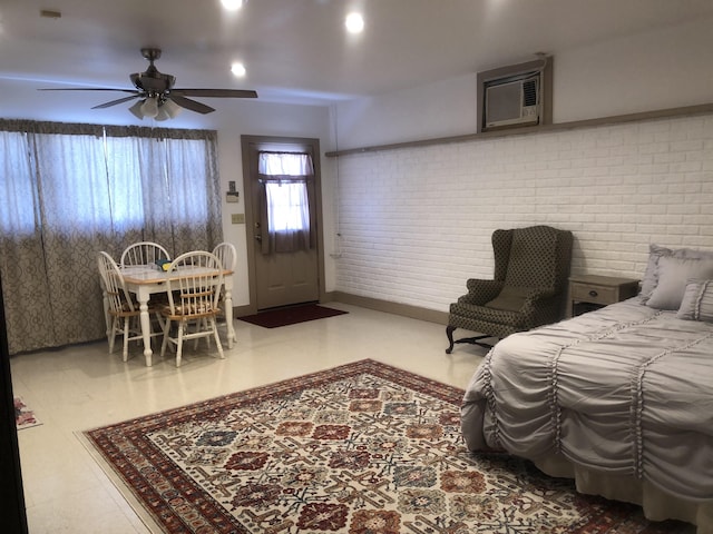 bedroom featuring ceiling fan, brick wall, and a wall mounted air conditioner