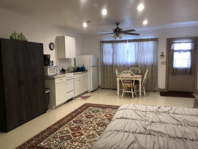 kitchen featuring ceiling fan, sink, white cabinets, and white appliances